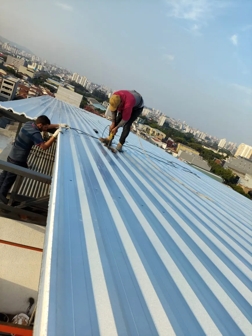 Equipe instalando as telhas de uma cobertura
