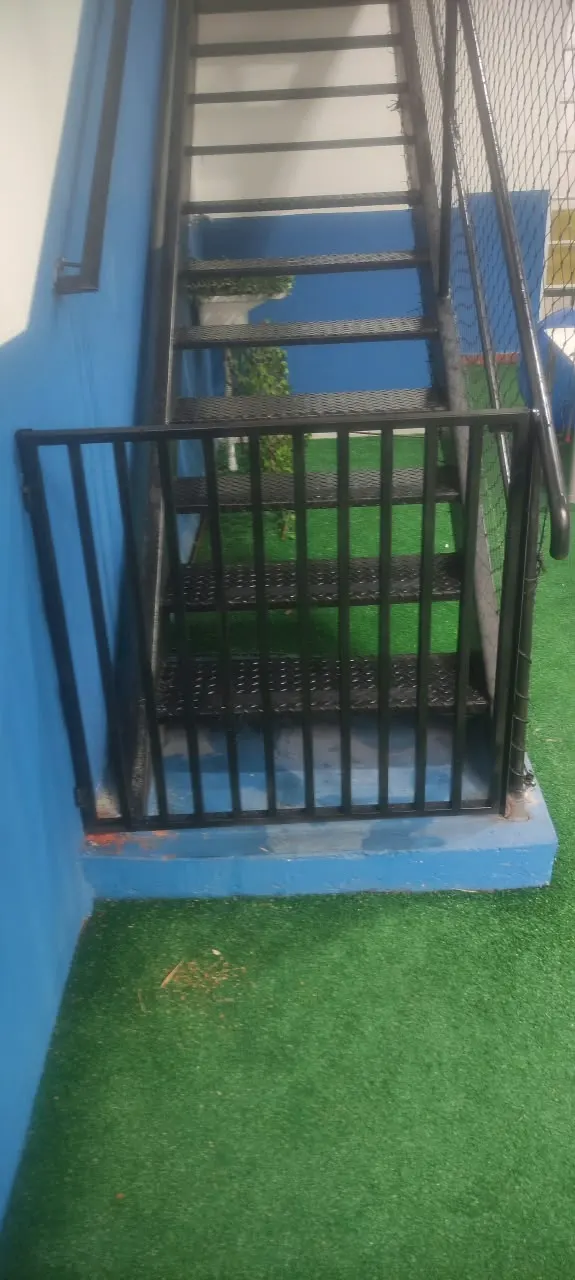 Guarda-corpo preto ao pé de uma escada