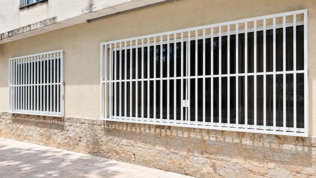Grades brancas em duas janelas de fachada