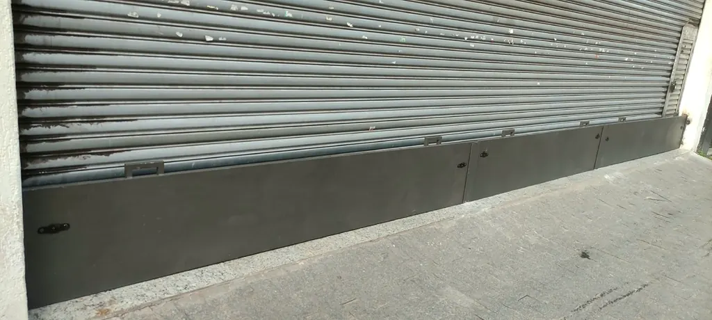 Chapa presa na base de uma porta de aço, complemento instalado pela JR