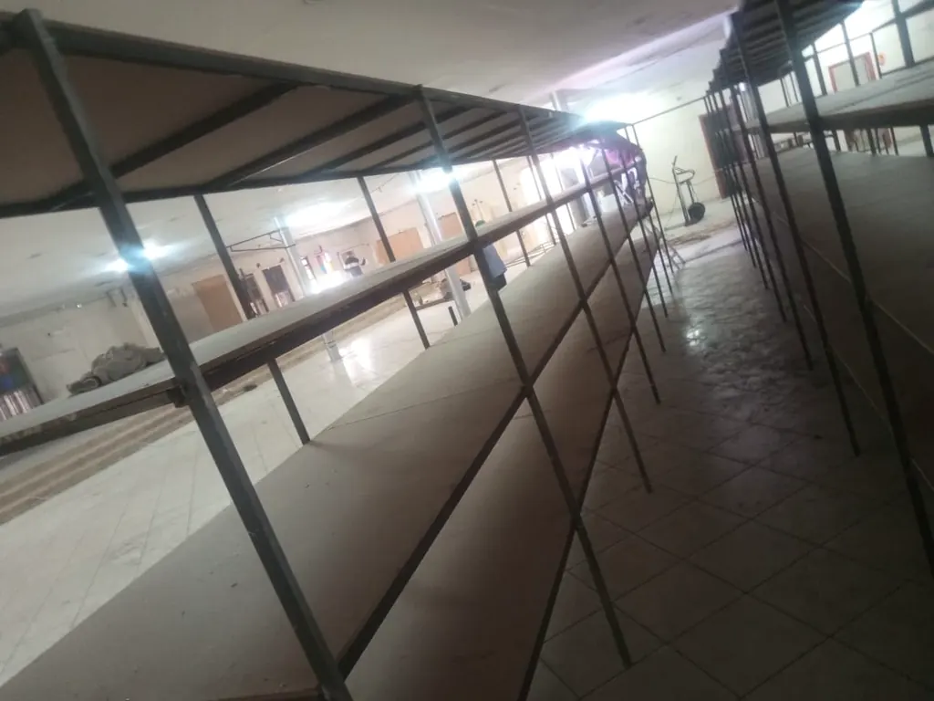 Corredor de estantes metálicas numa loja