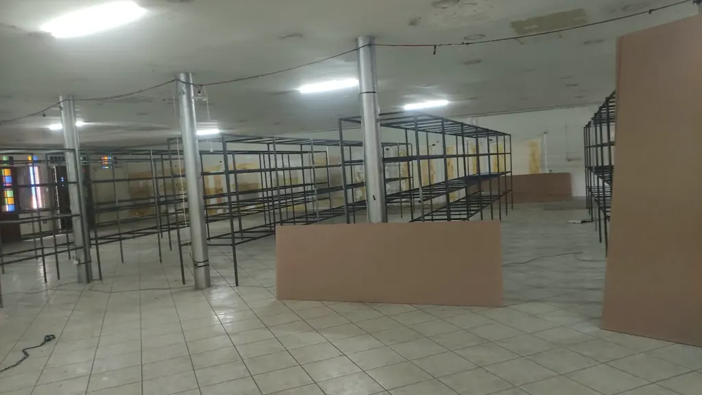 Estantes metálicas em montagem num salão grande