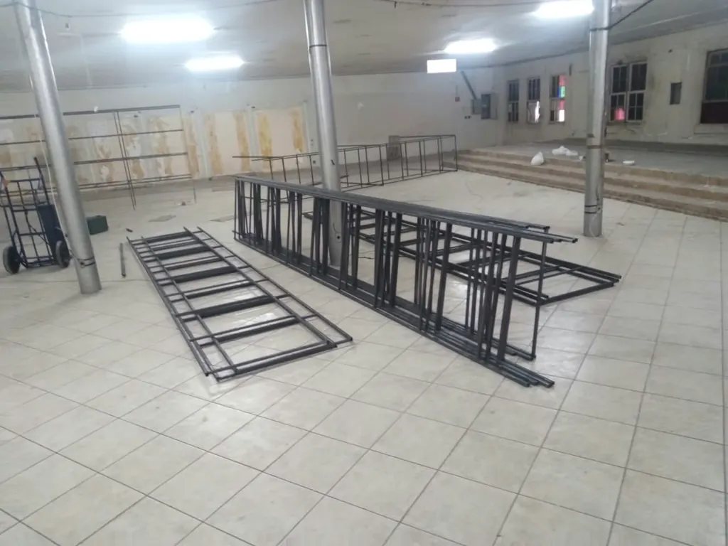 Peças de estante metálica no chão do salão, na montagem